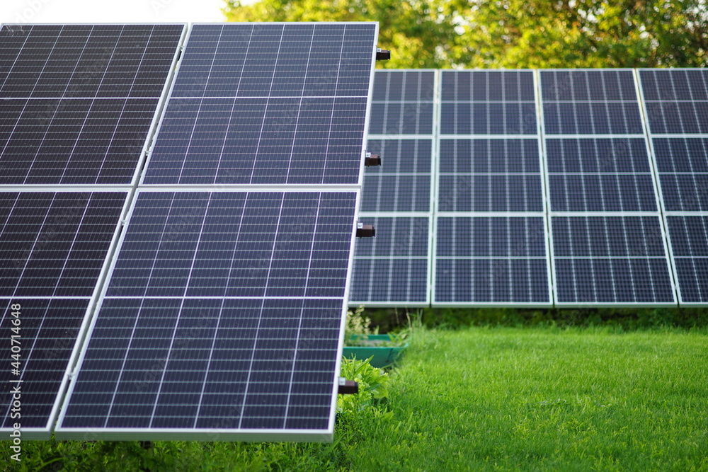 Solar panels stations on the green lawn in summer garden