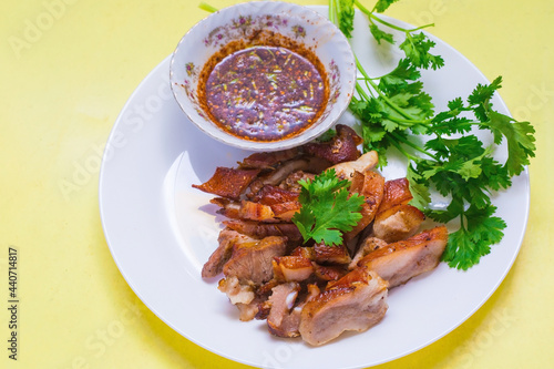Grilled pork mask was marinated with minced coriander root, black pepper and garlic and served with Thai spicy sauce (Jaew sauce).