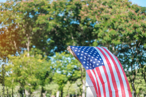 Woman traveling with United States of America flag in park outdoor. USA holiday of Veterans, Memorial, Independence ( Fourth of July) and Labor Day concept