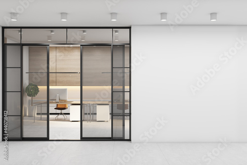 Blank light wall before the entrance to office area with work places, wooden wall and stylish tables with modern laptops. 3D rendering, mockup photo