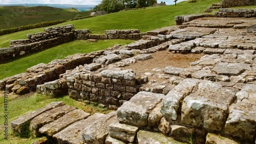 Walking the ruins of Housesteads Roman Fort on Hadrian's Wall, built by the Romans in AD 124 in Northumberland, England, UK. Hadrian's Wall is a UNESCO World Heritage Site photo