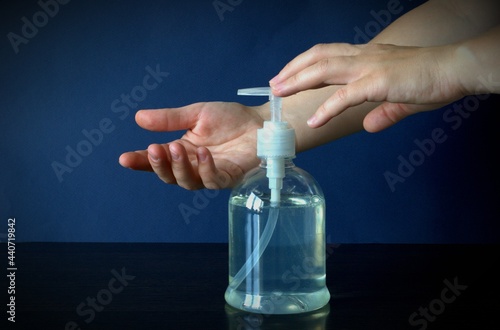 A woman's hand presses on the soap dispenser. Clean hands and good health. Hand washing.
