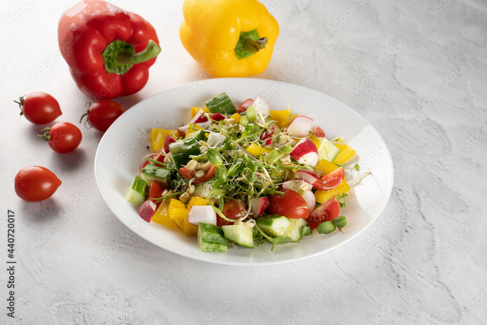 Wheat germ salad, tomatoes, peppers, radish, cucumber, olive oil. Vegetable salad on white plate on gray background. Wheat germ salad, tomatoes, peppers, radish, cucumber, olive oil. Vegetable salad on white plate on gray background.