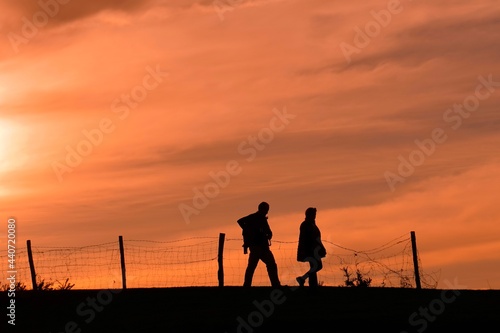 silhouette of a couple trekking in the mountian with a sunset