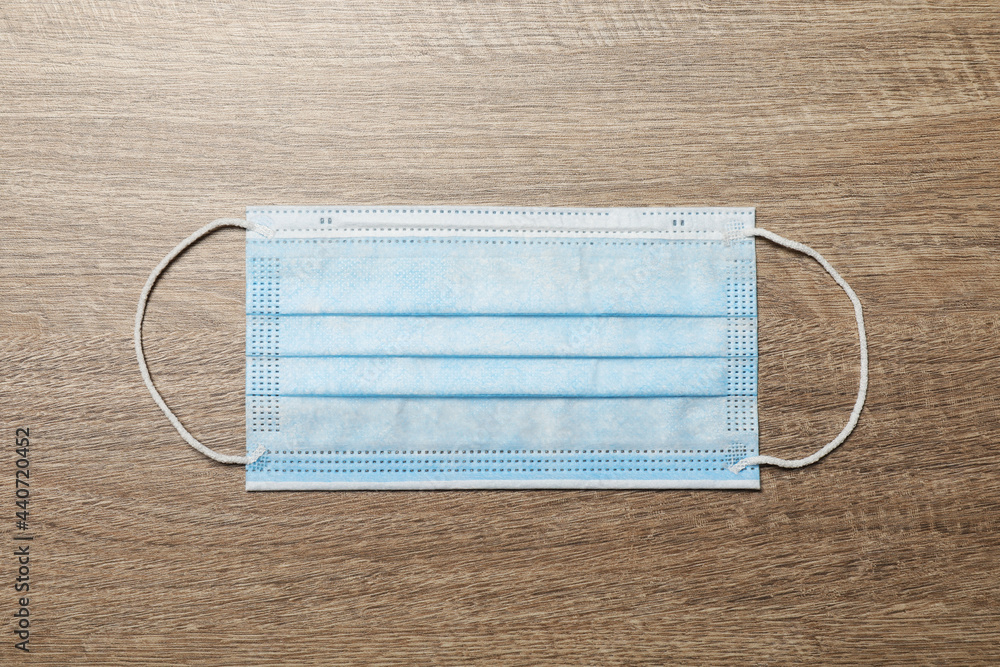 Protective mask on wooden background, top view. Safety equipment Protective mask on wooden background, top view. Safety equipment