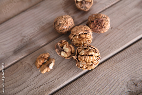 Walnuts scattered on wooden background