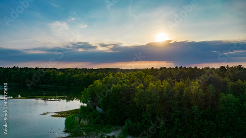 Aerial view of a beautiful and dramatic sunset over a forest lake reflected in the water  landscape drone shot. Blakheide  Beerse  Belgium. High quality photo