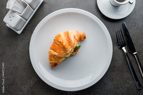 Delicious brunch, breakfast - coffee and croissant sandwich with cream cheese, salmon