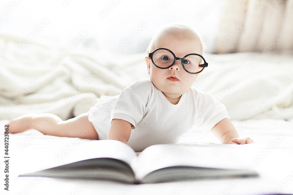 A newborn baby is lying on a soft bed in glasses. A newborn baby is lying on a soft bed in glasses.