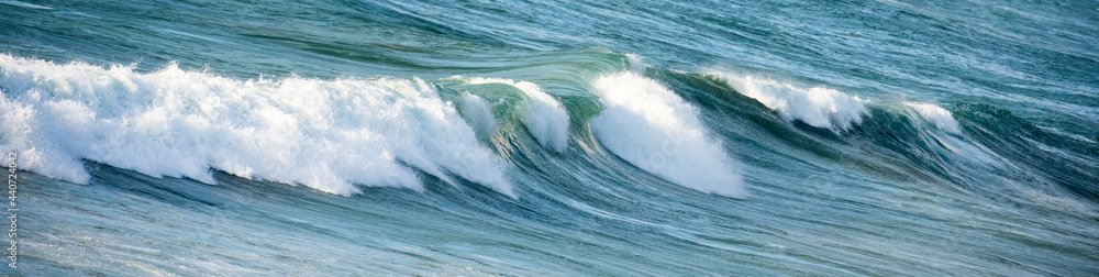 Breaking wave in a blue sea water
