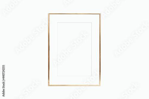 Thin gold frame with mat on a white wall