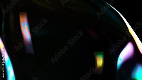 Super slow motion of flying huge bubble on black background, close-up. Filmed on high speed cinema camera, 1000fps.