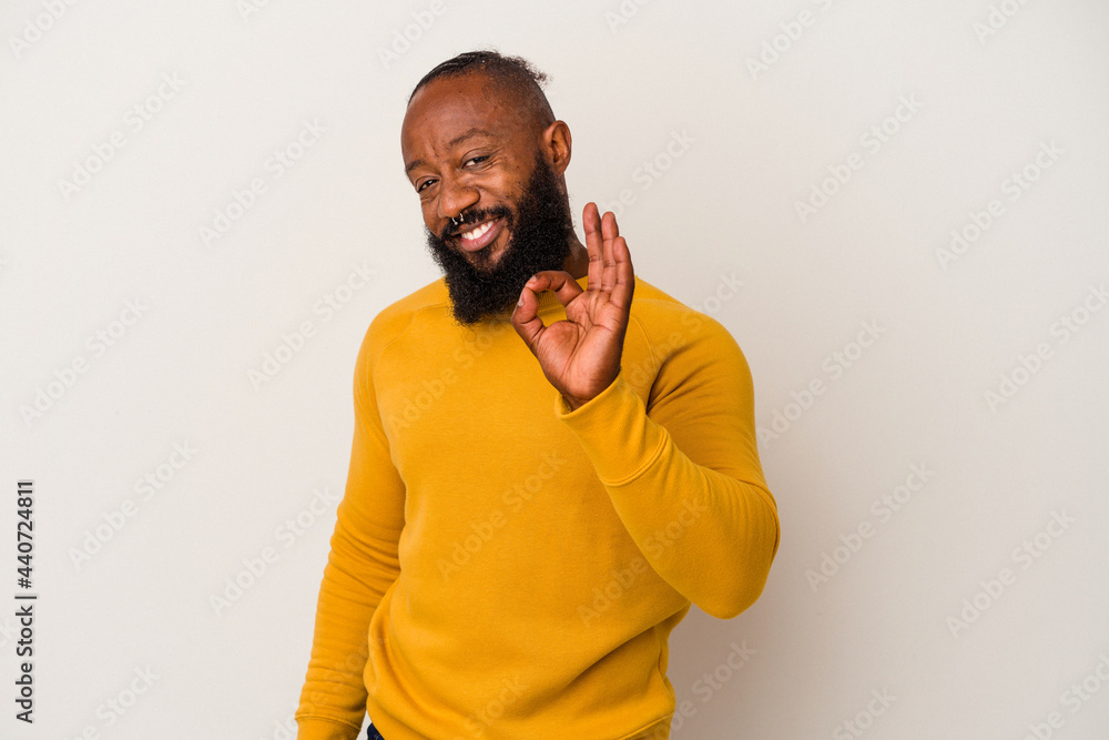 African american man with beard isolated on pink background winks an eye and holds an okay gesture with hand. African american man with beard isolated on pink background winks an eye and holds an okay gesture with hand.