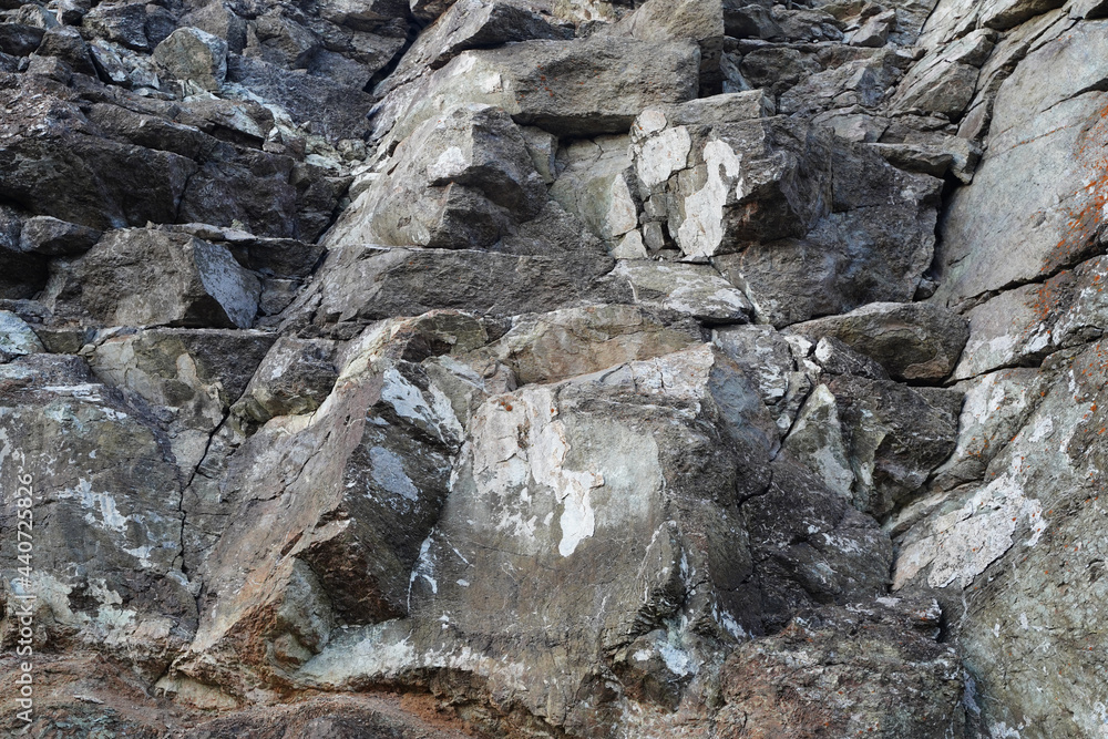 Texture of natural stone rock, background wallpaper white, gray and black splashes on the surface. Horizontal rectangular photography