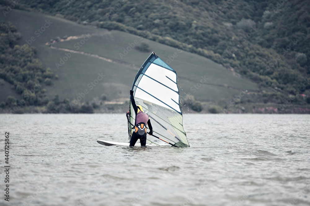 Naklejka premium Windsurfer surfing on a windy day at the river.