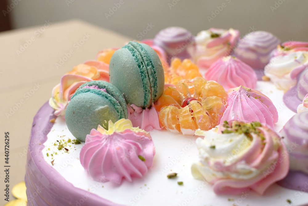Decoration on the cake of macaroni, tangerine and whipped cream in the form of flowers Decoration on the cake of macaroni, tangerine and whipped cream in the form of flowers