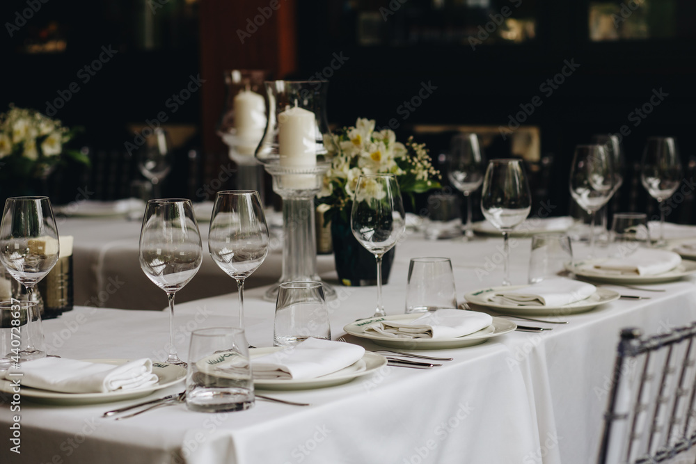 tableware Glasses, flower fork, knife served for dinner in restaurant with cozy interior tableware Glasses, flower fork, knife served for dinner in restaurant with cozy interior
