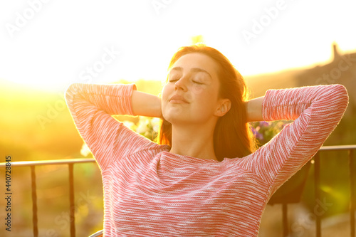 Relaxed woman resting in a balcony at sunset #440728845