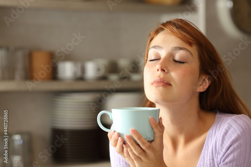 Woman relaxing drinking coffee in the kitchen