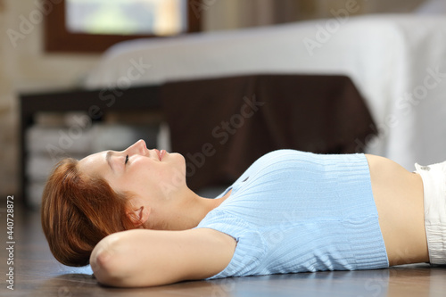 Happy woman relaxing lying on the floor of the bedroom