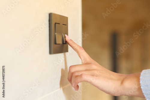 Bilde på lerret Woman hand pushing light switch at home