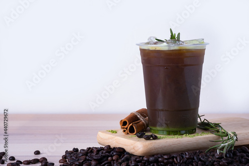 cold espresso black coffee matcha green tea mix with green tea poeder and coffee beans on cut board with copy space for text. coffee menu concept. photo