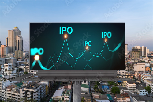 IPO icon hologram on road billboard over sunset panorama city view of Bangkok. The hub of initial public offering in Southeast Asia. The concept of exceeding business opportunities.