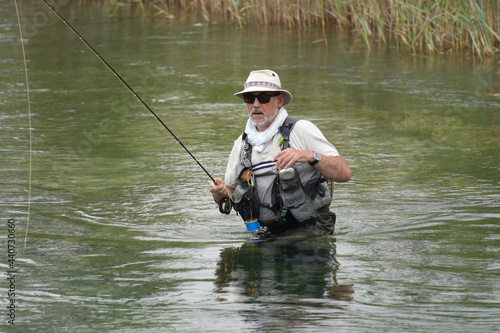 fly fisherman fishing in a small wild river