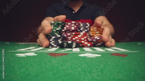 Male player betting all chips in while playing in casino, close up