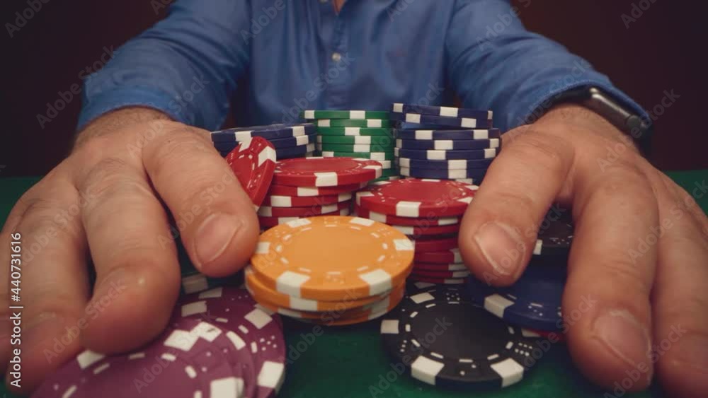 Male player betting all chips in while playing in casino, close up Male player betting all chips in while playing in casino, close up