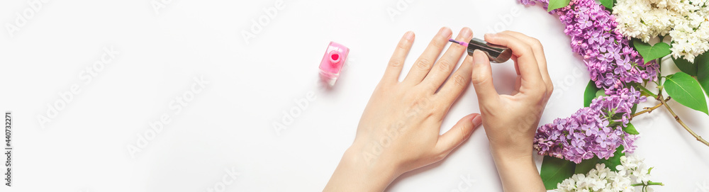 Fototapeta premium woman paints her nails with varnish, close-up. Beauty concept. Banner