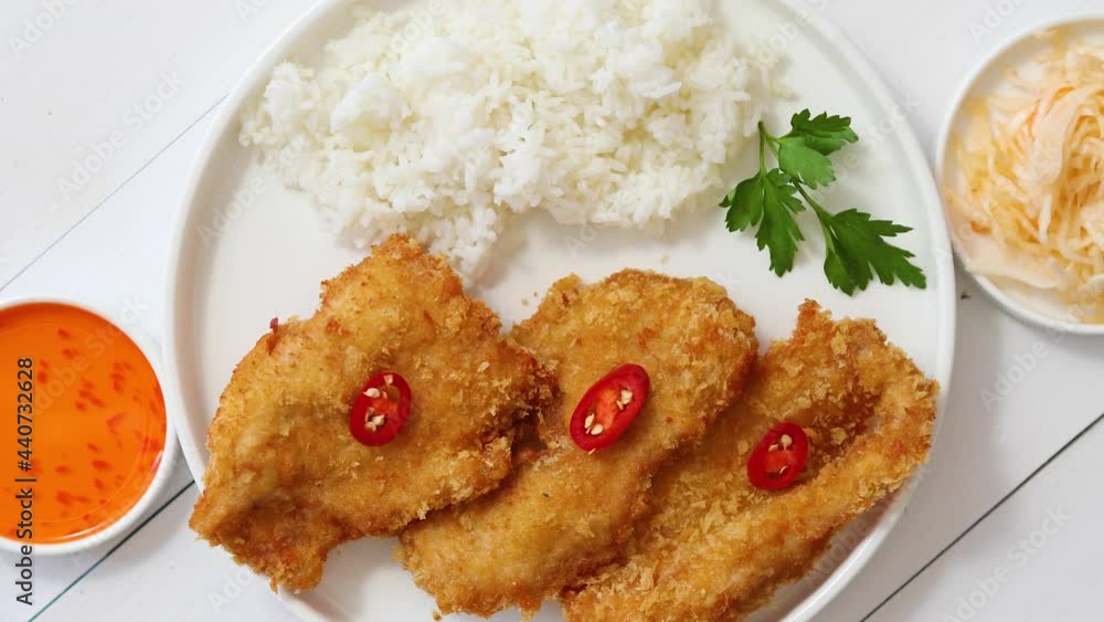 Crispy chicken fried in breadcrumbs served with rice. View from the top on white wooden background Crispy chicken fried in breadcrumbs served with rice. View from the top on white wooden background
