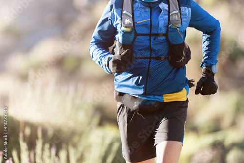 Male athlete run mountain race wth hydratation trail vest for running photo