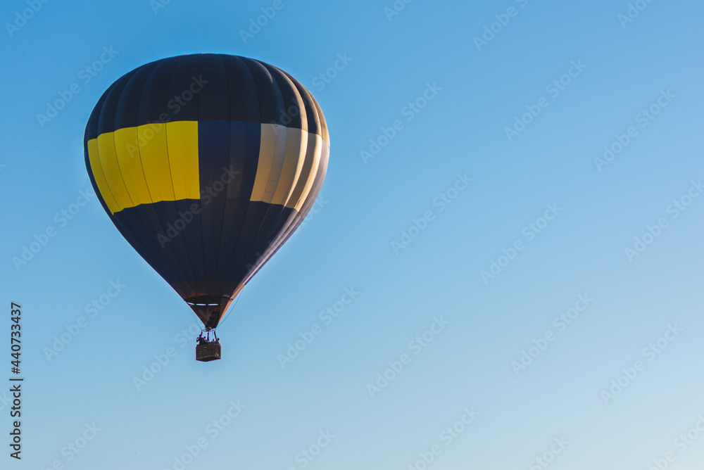 Fototapeta premium Hot Air Balloon on a blue sky.One Blue yellow hot air balloon in blue clear sky.Copy space.