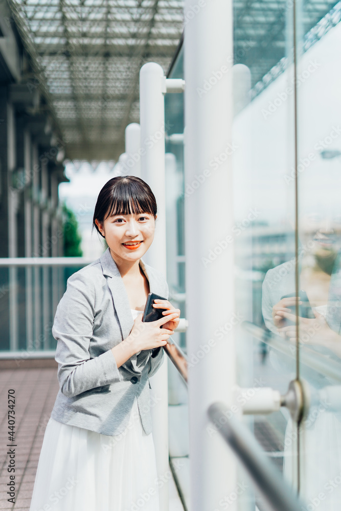 Fototapeta premium 外で待ち合わせをする若いビジネスウーマン