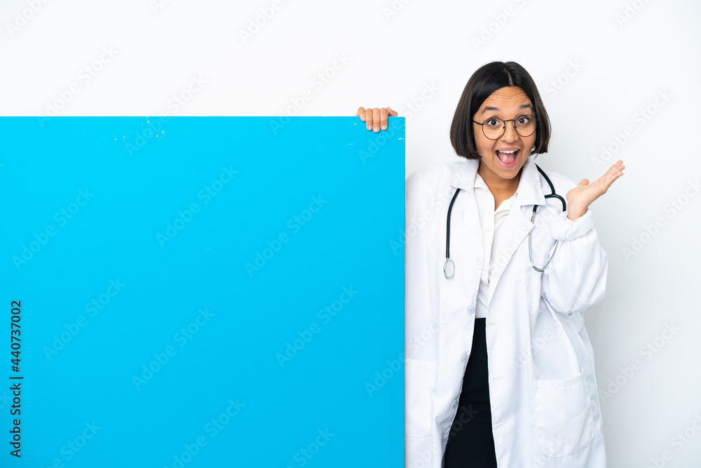 Young mixed race doctor woman with a big placard isolated on white background with shocked facial expression Young mixed race doctor woman with a big placard isolated on white background with shocked facial expression