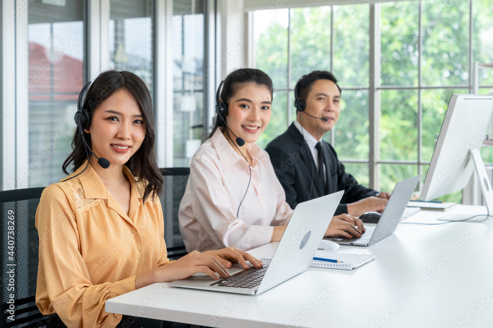 Asian female telemarketer operators, Technical support use headset to call answer client questions in a contact call center. Group of Business telemarketing, Customer service, Communication telephone Asian female telemarketer operators, Technical support use headset to call answer client questions in a contact call center. Group of Business telemarketing, Customer service, Communication telephone
