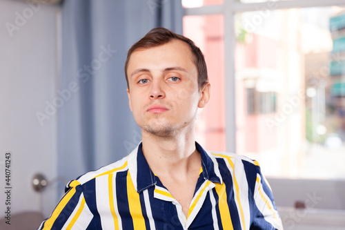 Attractive young man in a striped shirt at home photo