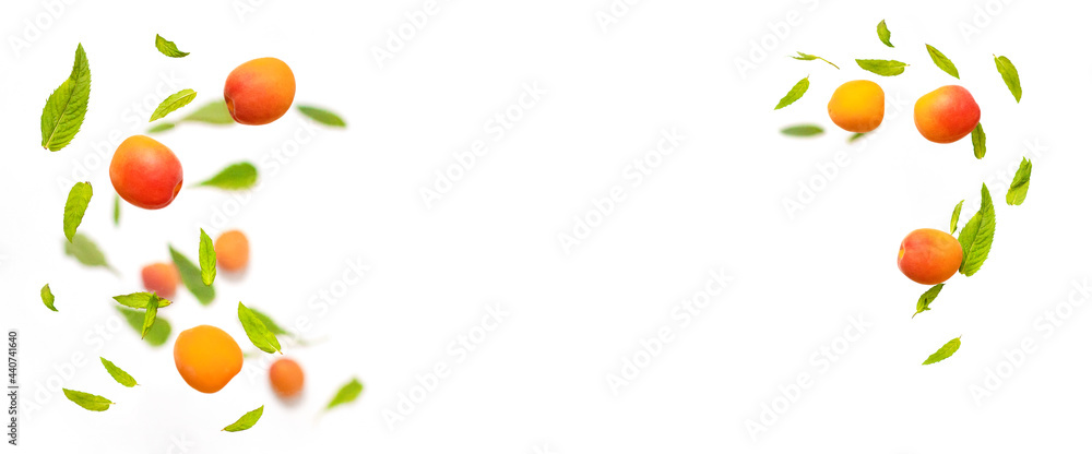 Falling juicy ripe apricot with green leaves isolated on white background. Flying defocusing slices of fruit. Food levitation concept