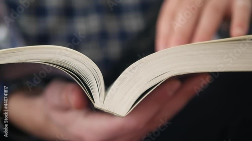 Man reads book and turns pages close up