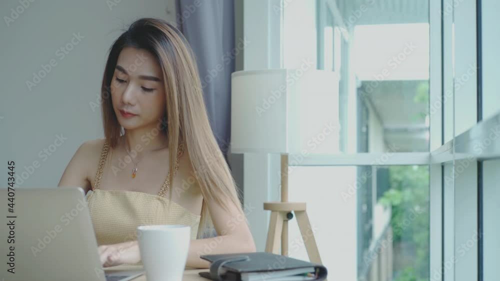 Mobile payment concept : Young beautiful Asian woman enjoying a relaxing moment working and using mobile phone as mobile smart payment to pay for a coffee in the coffeeshop on a bright sunny day Mobile payment concept : Young beautiful Asian woman enjoying a relaxing moment working and using mobile phone as mobile smart payment to pay for a coffee in the coffeeshop on a bright sunny day