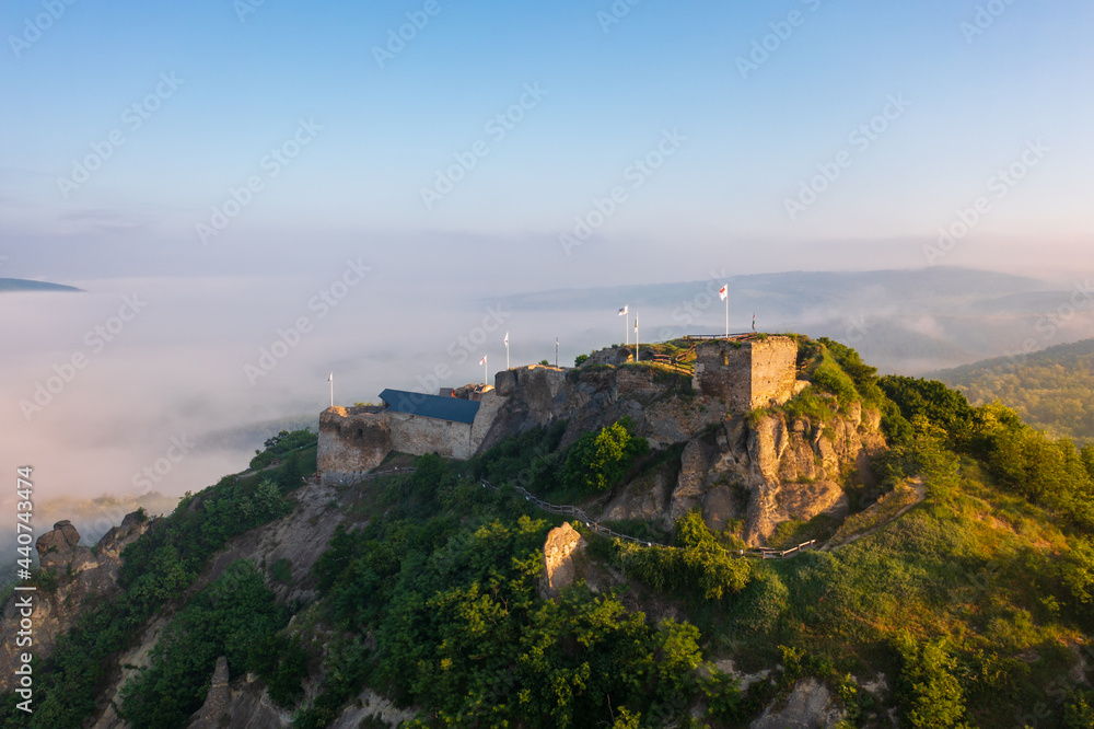 Aerial view abour castle of Sirok with misty matra mountains at the background. Spring sunrise landscape.