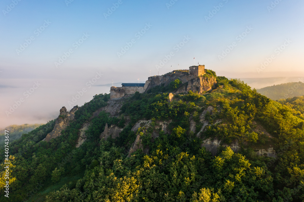 Aerial view abour castle of Sirok with misty matra mountains at the background. Spring sunrise landscape.