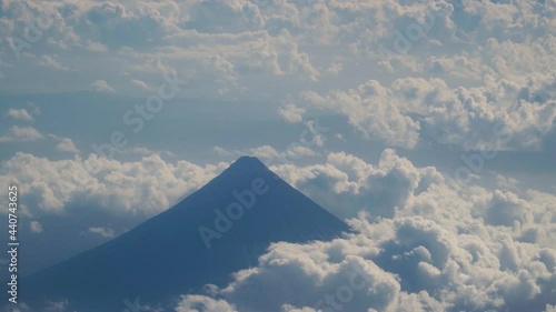 View through an airplane window on the Mayon vlcano, mountains, sky and clouds. Rocky Mountains through Airplane Window. photo
