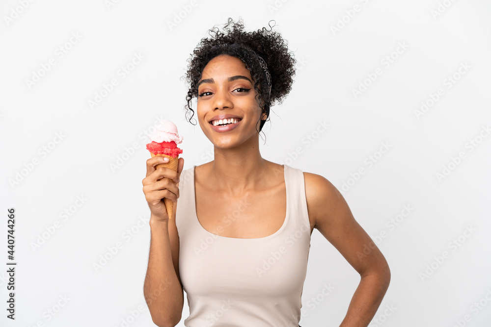 Young african american woman with a cornet ice cream isolated on white background posing with arms at hip and smiling Young african american woman with a cornet ice cream isolated on white background posing with arms at hip and smiling