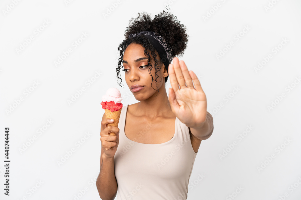 Young african american woman with a cornet ice cream isolated on white background making stop gesture and disappointed Young african american woman with a cornet ice cream isolated on white background making stop gesture and disappointed