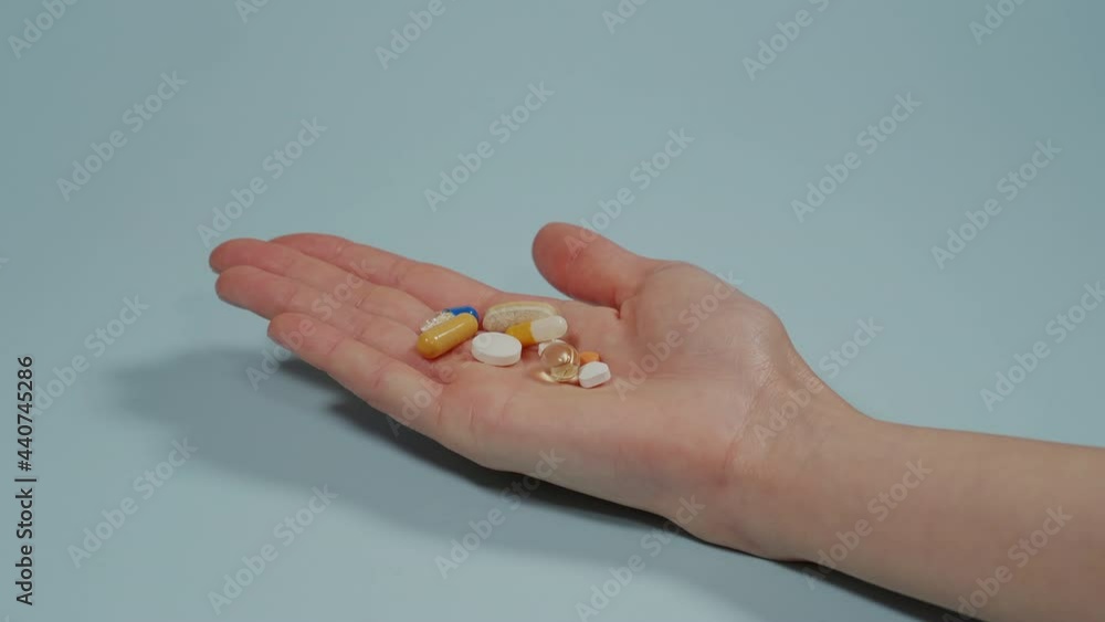 Handful of tablets and capsules of various shapes and colors lie in the palm of your hand. Painkiller pill, Antibiotics pill, Swelling pill and Calcium tablet in the palm for spine subsidence. Handful of tablets and capsules of various shapes and colors lie in the palm of your hand. Painkiller pill, Antibiotics pill, Swelling pill and Calcium tablet in the palm for spine subsidence.