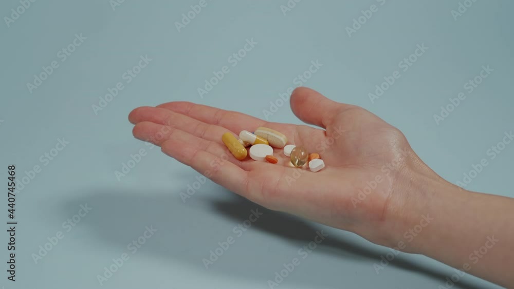 Handful of tablets and capsules of various shapes and colors lie in the palm of your hand. Painkiller pill, Antibiotics pill, Muscle Dehydration pill Handful of tablets and capsules of various shapes and colors lie in the palm of your hand. Painkiller pill, Antibiotics pill, Muscle Dehydration pill