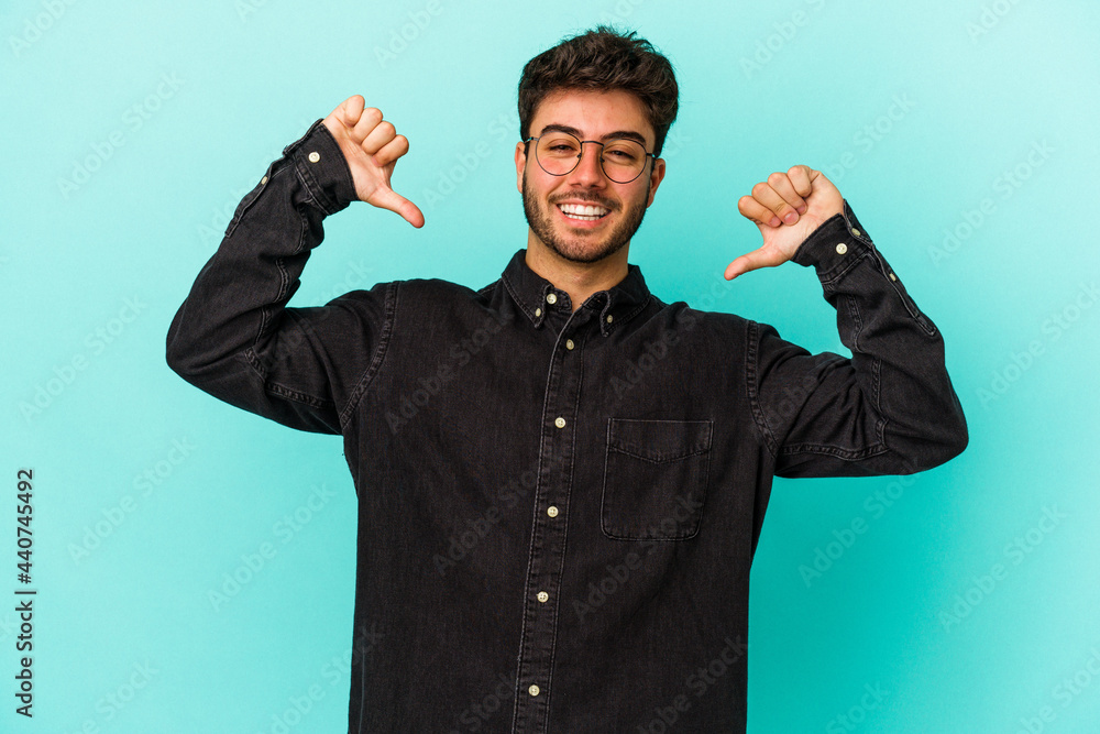 Fototapeta premium Young caucasian man isolated on blue background feels proud and self confident, example to follow.