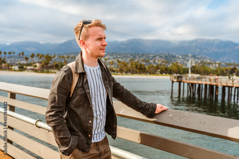 A young man stands on a pier in Santa Barbara, California, USA A young man stands on a pier in Santa Barbara, California, USA